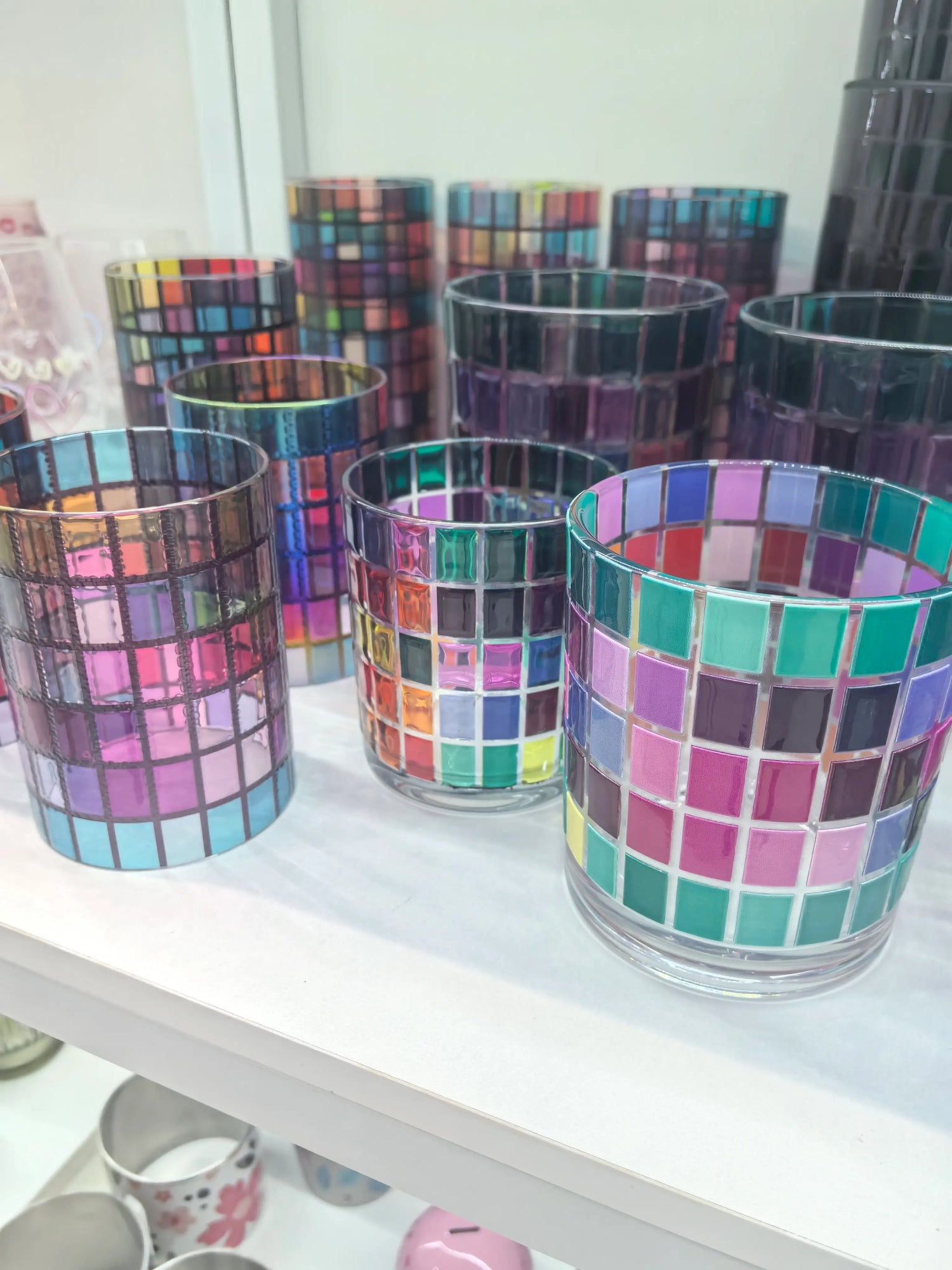 Close-up of colorful decorative glass candle vessels in the Verse & Vessel showroom