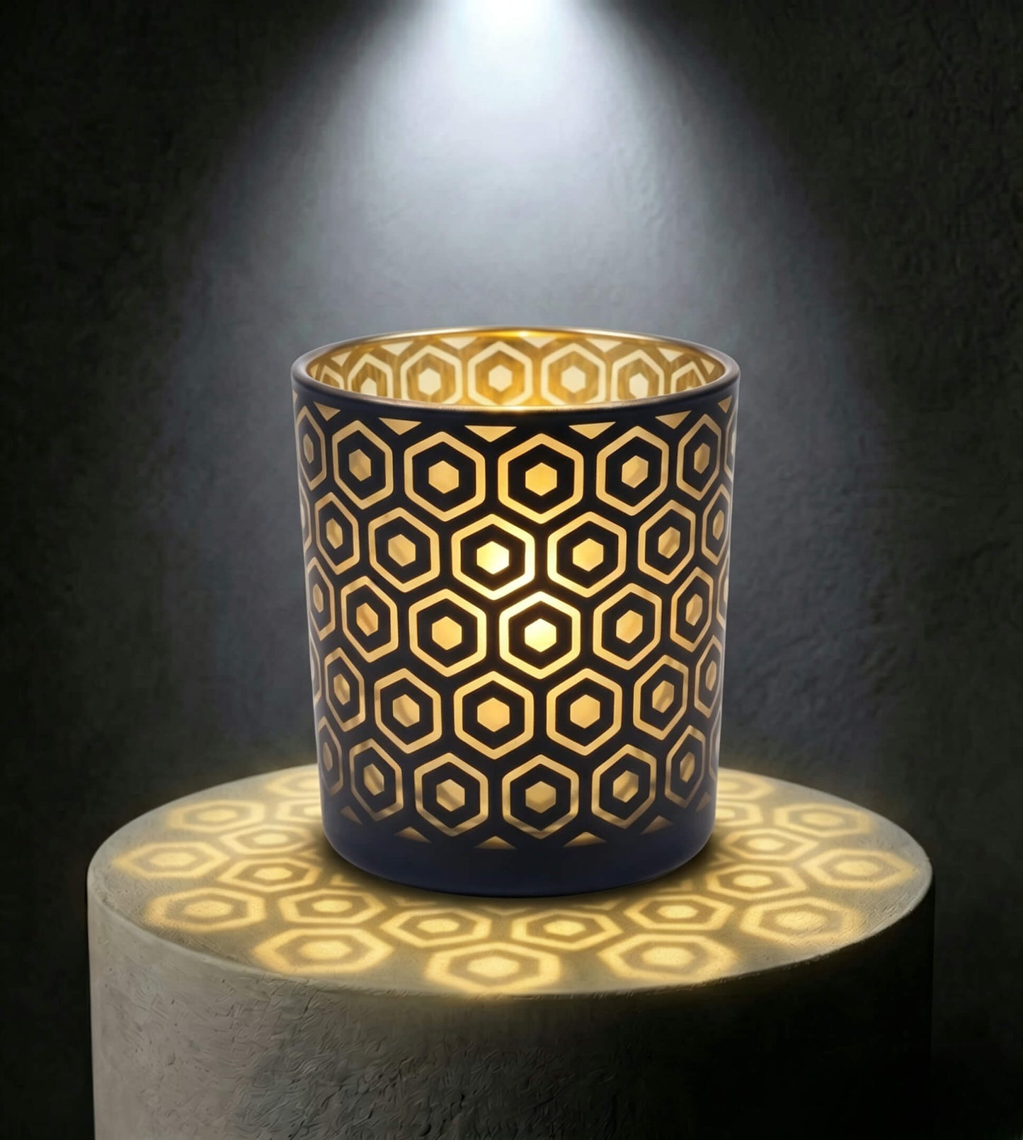 Wholesale matte black and gold hexagon cut out candle vessel 8 oz casting honeycomb light shadows under spotlight