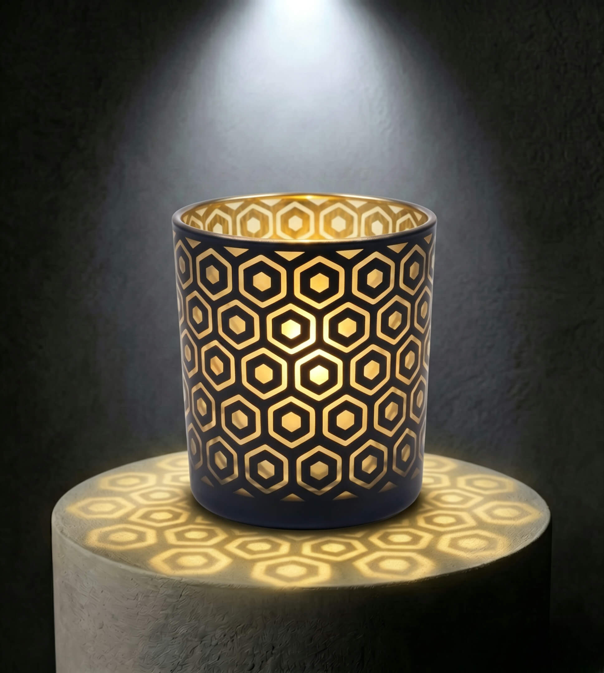 Wholesale matte black and gold hexagon cut out candle vessel 8 oz casting honeycomb light shadows under spotlight