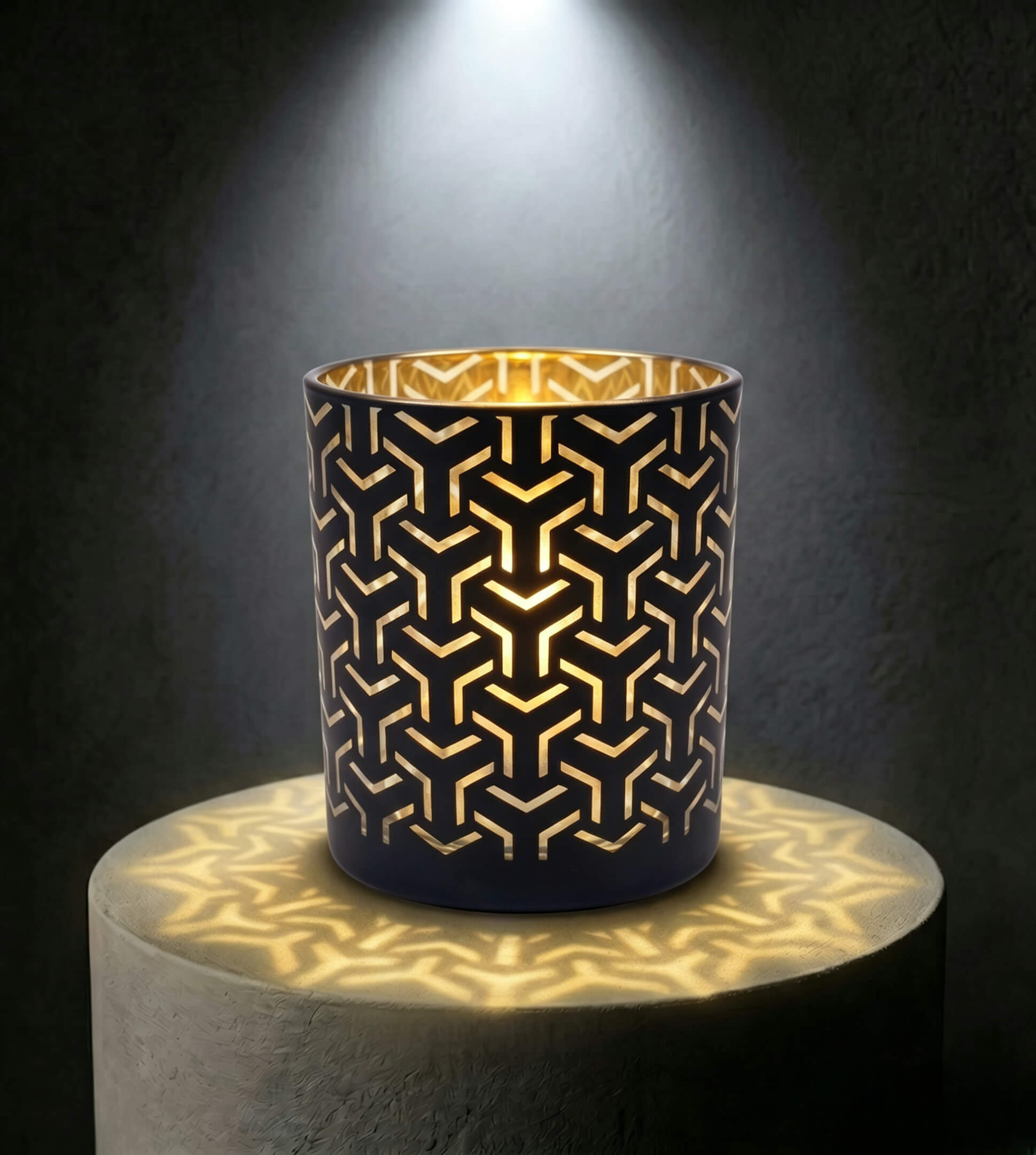 Wholesale matte black and gold labyrinth cut out candle vessel 8 oz casting intricate geometric shadows under spotlight