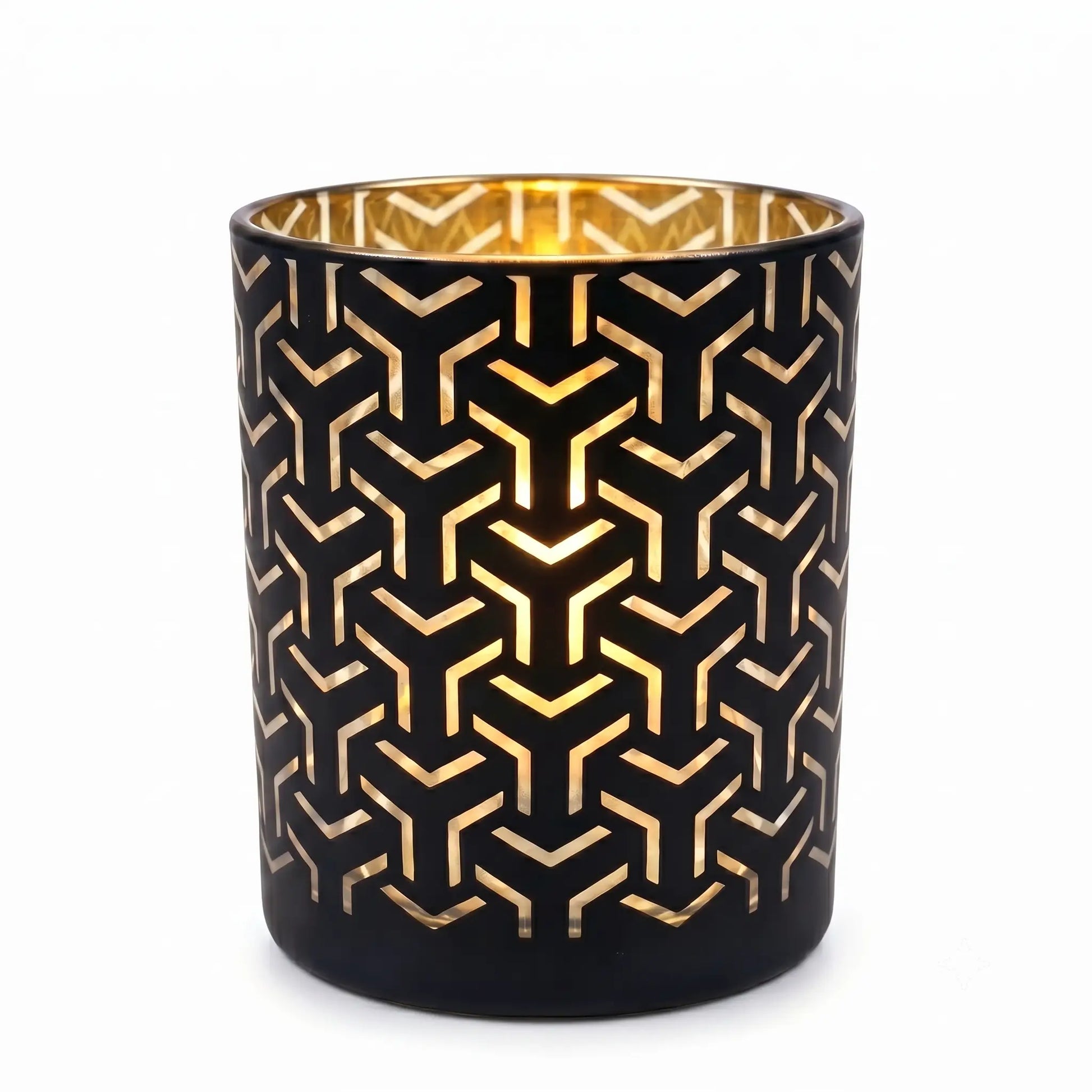 Wholesale matte black and gold labyrinth cut out candle vessel 8 oz casting intricate geometric shadows under spotlight
